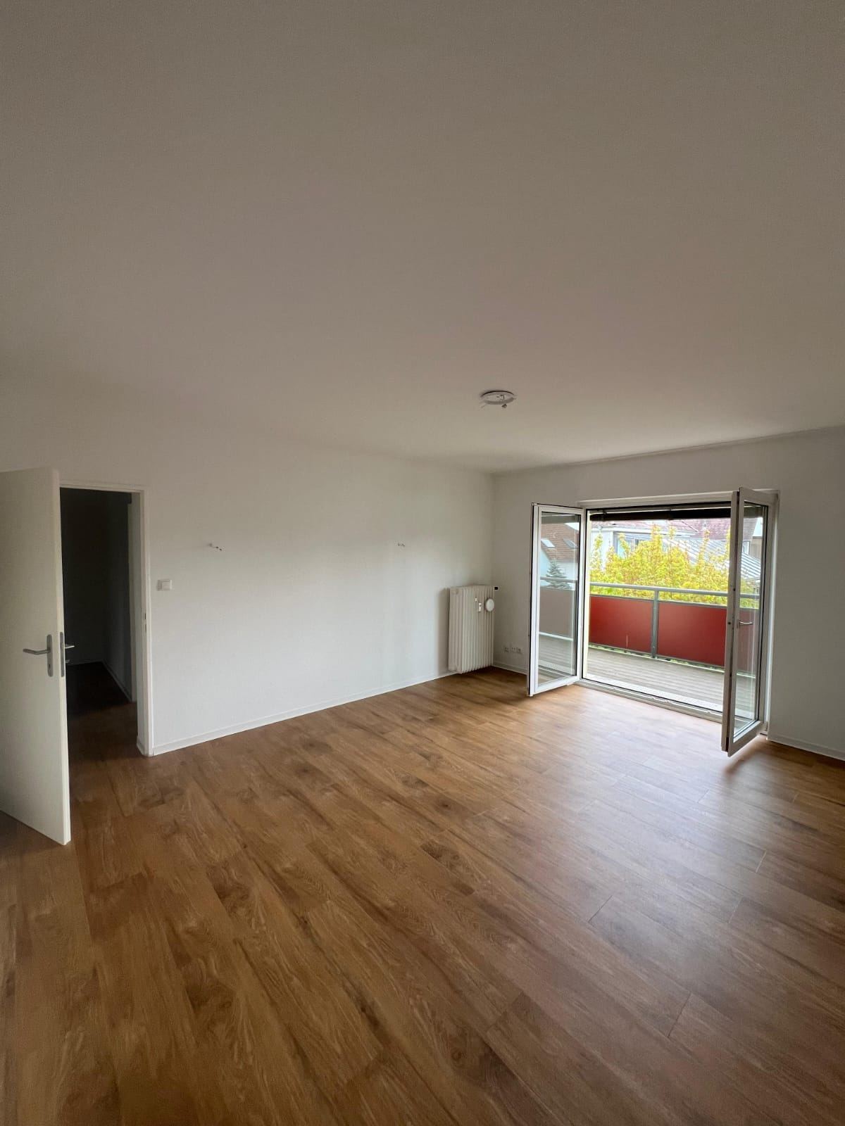 Saniertes Wohnzimmer mit neuem Bodenbelag und Zugang zum Balkon, Dachgeschosswohnung Am Hollerbusch, Wiesbaden